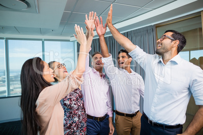 Business colleagues giving high five during meeting in office