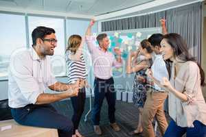 Portrait of smiling business colleagues cheering with fists up