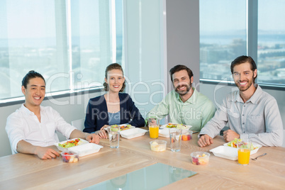 Smiling business executives having meal in office