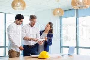 Architects discussing over digital tablet in conference room