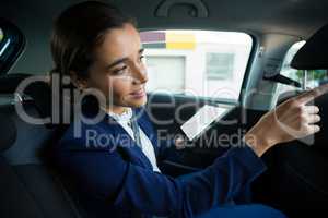 Business executive using digital tablet in car