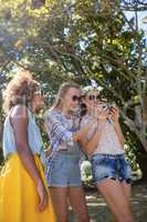 Female friends looking at mobile phone in park