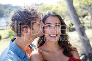 Man kissing woman on cheek