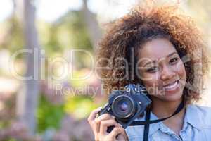 Smiling woman standing with digital camera