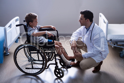 Male doctor interacting with child patient in ward