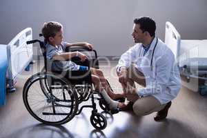 Male doctor interacting with child patient in ward