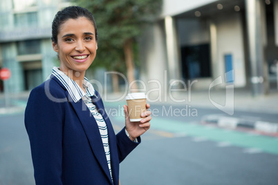 Business executive holding disposable coffee cup