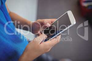 Schoolboy using mobile phone in corridor at school