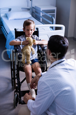 Male doctor interacting with child patient in ward