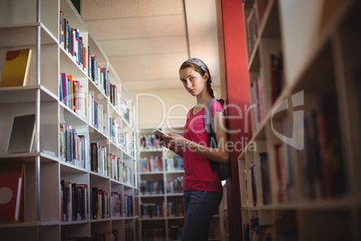 Portrait of schoolgirl using digital tablet in library