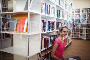 Portrait of smiling schoolgirl in library