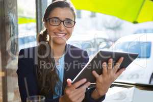 Business executive using digital tablet in cafÃ?Â©