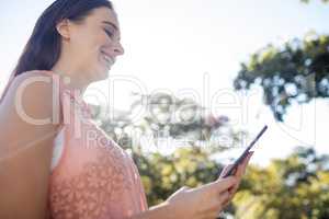 Smiling woman using a digital tablet in the park