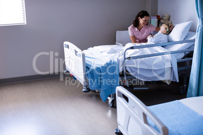 Female doctor consoling patient during visit in ward