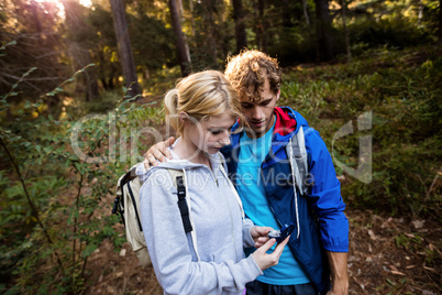 Hiking couple checking the compass