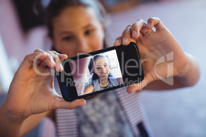 Schoolgirl taking selfie on mobile phone