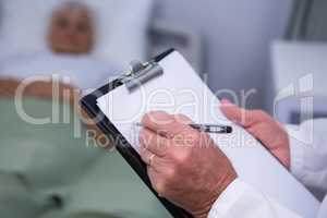 Doctor writing on clipboard