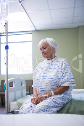 Worried senior patient sitting on bed