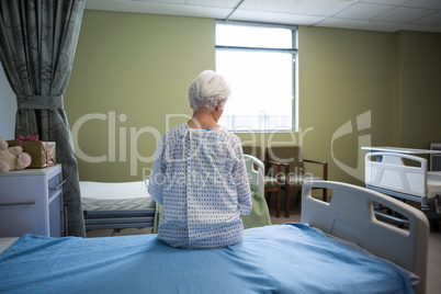 Thoughtful senior patient sitting at hospital