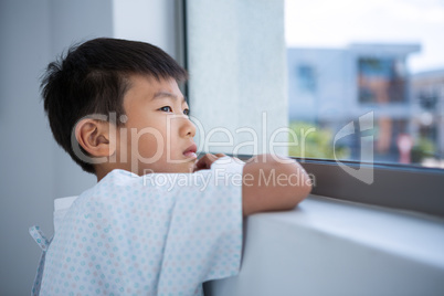 Boy patient looking out from the window at hospital