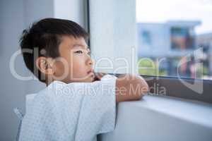 Boy patient looking out from the window at hospital