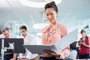 Business executive holding clipboard at desk in office