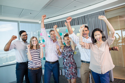 Portrait of smiling business colleagues cheering with fists up