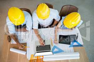 Architects discussing over laptop in conference room