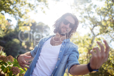 Happy man playing air guitar in park