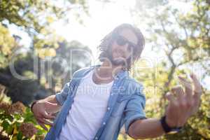 Happy man playing air guitar in park