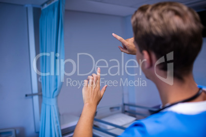 Rear view of doctor gesturing in ward