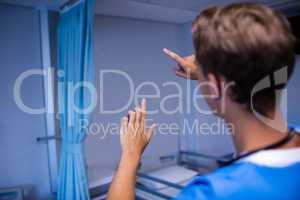 Rear view of doctor gesturing in ward