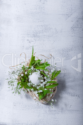 Egg and flowers on a white surface. Easter symbols