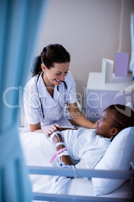 Female doctor consoling patient during visit in ward