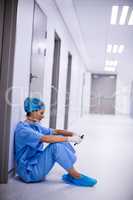 Surgeon sitting on floor and using mobile phone