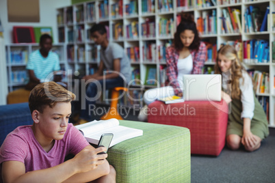 Student using mobile phone in library