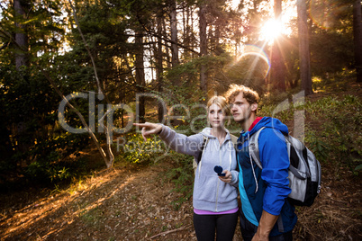 Hiking couple holding a compass and pointing