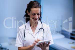 Female doctor using digital tablet in ward