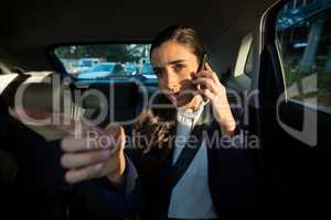 Business executive talking on mobile phone in car