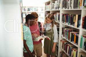 School kids reading books in library at school