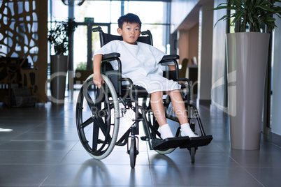 Disabled boy patient on wheelchair in hospital corridor