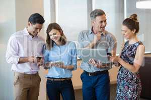 Business colleagues using mobile phone, digital tablet and laptop