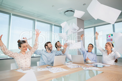 Group of business executives celebrating by throwing their business papers in the air