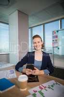 Business executive using her mobile phone at office