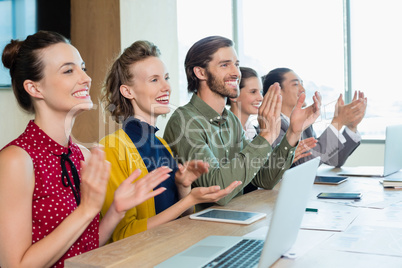 Business team applauding during meeting in conference room
