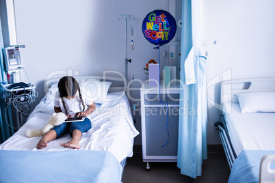 Patient using digital tablet on bed