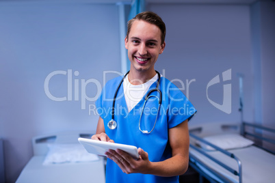 Doctor using digital tablet in ward at hospital