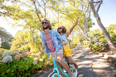 Couple having fun while cycling in the park