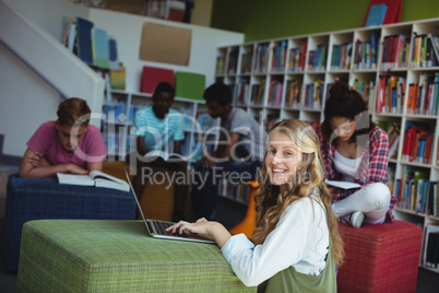 Portrait of happy student studying in library