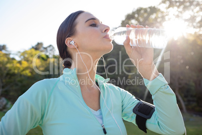 Female jogger drinking water in park
